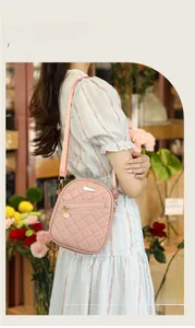 Detail of pink quilted crossbody bag featuring gold hardware and adjustable strap