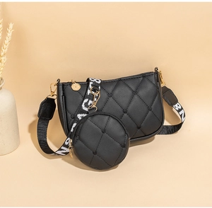 Détail du sac hobo matelassé noir avec pochette ronde assortie et bandoulière tissée