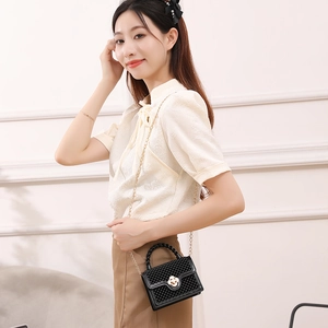 Mini sac gelée noir avec texture perlée et fermoir fleur dorée sur bandoulière chic