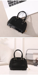 Detail of mini black pearl jelly bag with golden zipper and beaded surface texture