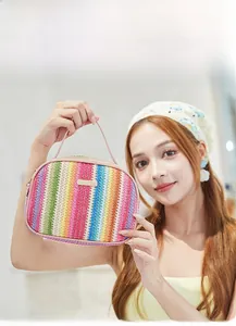 Detailed view of a rainbow woven crossbody bag with gold metal plate and zipper closure