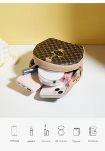 Interior capacity view of round crossbody bag showing phone and cosmetics space