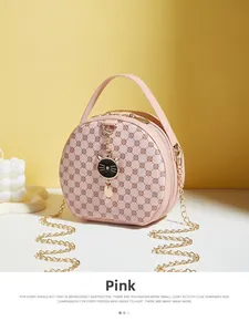 Close-up of pink round mini bag with vintage floral texture and black cat charm