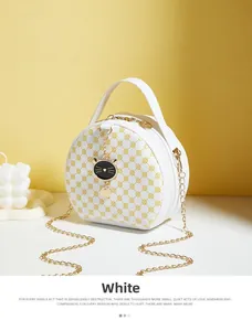 Close-up of small round crossbody bag with floral pattern and golden metal handle