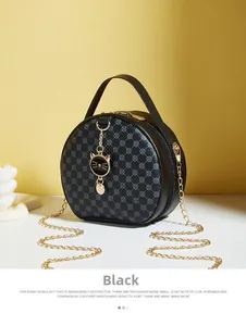 Detail of black round crossbody bag with grey clover print and golden cat charm pendant