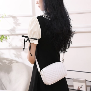 Sac bandoulière en simili cuir blanc avec surpiqûres en V présenté sur un mannequin