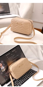 Detail of beige square crossbody bag featuring premium chevron stitching and gold hardware