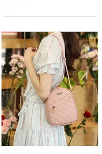 Detailed view of pink quilted PU leather shoulder bag worn by model in floral setting