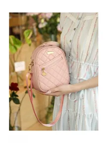 Detail of pink quilted mini backpack showing metallic zippers and premium faux leather texture