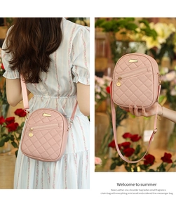 Detail of pink quilted crossbody bag with golden hardware and adjustable fabric strap