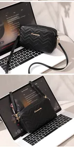 Close-up of black quilted crossbody bag with golden Sunnagetty logo and V-shaped stitching