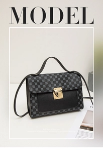 Détail du sac bandoulière bicolore gris et noir avec boucle dorée et motifs à pois