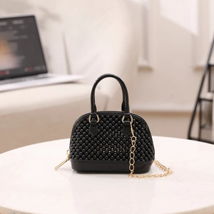 Mini black PVC shell bag with bead texture, golden chain strap, and top handle