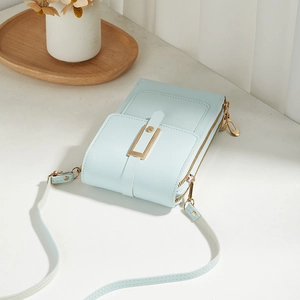 Minimalist light blue vertical phone shoulder bag with gold buckle and double zipper details