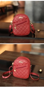Detail of red quilted mini backpack with gold zippers and a polished metal nameplate