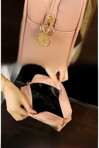 Detail of pink PU leather camera bag featuring a smooth gold zipper and wide black interior