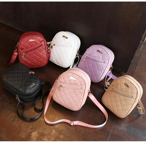 Detailed view of quilted crossbody bags in six colors on a dark wooden background