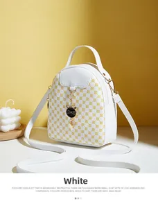 Mini white backpack featuring yellow polka dots and a cute cat metal charm detail