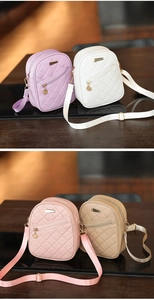 Close-up of quilted round crossbody bags in purple, white, pink, and khaki with gold hardware