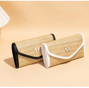 Close-up of woven straw texture and elegant white butterfly buckle on small square bags