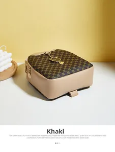 Close-up of khaki leather backpack featuring cat-shaped metal charm and quilted flap detail