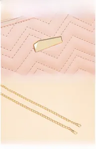Close-up of pink V-quilted bag with golden geometric clasp and fine chain strap