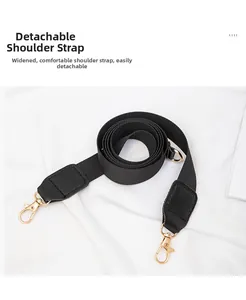 Close-up of detachable wide fabric shoulder strap with gold metal hooks and leather accents