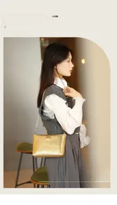 Detail of golden metallic shoulder bag with wavy texture and rectangular buckle accent