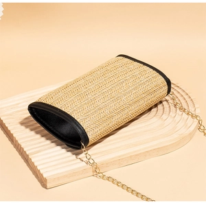 Detail showing woven texture and black leather trim of this elegant chain crossbody bag