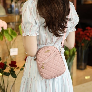 Pink quilted PU leather crossbody bag with gold hardware shown on model in a flower shop