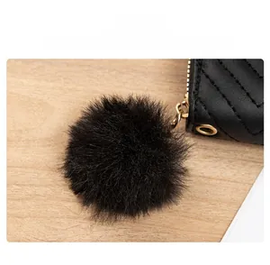 Detail der schwarzen gesteppten Lederbörse mit weichem Pompon-Zipper und Gold-Beschlägen