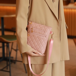 Pink quilted crossbody phone bag with three zipper compartments and gold metal details