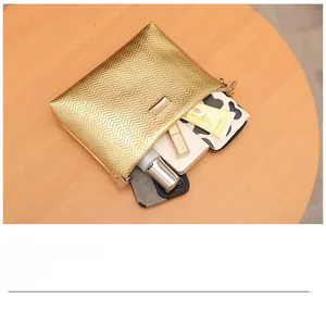 Detailed top view of golden wavy textured pouch showing internal storage space for cosmetics