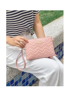 Close-up of pink chevron quilted PU clutch bag with gold hardware and wrist strap