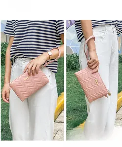 Detailed pink wave quilted handbag with gold hardware and leather wrist strap