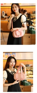 Close-up of pink quilted round Boston bag with wide fabric handle in cafe setting