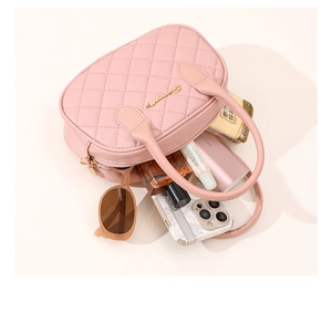 Detail of pink quilted handbag showing spacious interior with phone and accessories