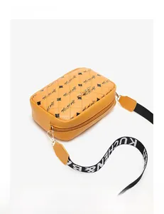 Detail of yellow quilted crossbody bag with black Luck For You print and wide strap