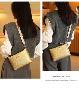 Detail of golden chevron embossed crossbody bag with adjustable wide fabric strap