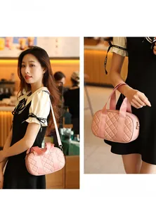 Detailed view of pink quilted mini Boston bag with shoulder strap in a cafe setting