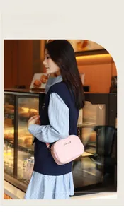 Détail d'un sac bandoulière matelassé rose avec chaîne métallique dans un café