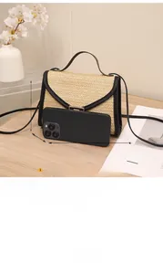 Straw flap bag with black leather trim and gold buckle, size 20x14x5cm shown with phone