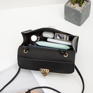 Sac bandoulière à damier en cuir noir montrant la capacité intérieure pour les essentiels