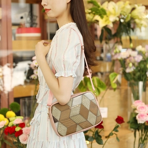 Chic geometric color-block crossbody bag with leather texture in a floral shop setting