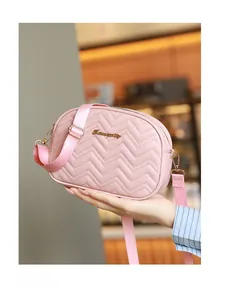 Détail d'un sac à bandoulière rose matelassé avec motif à vagues et logo en métal doré