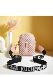 Detail of light pink mini crossbody bag featuring dot prints and wide logo shoulder strap
