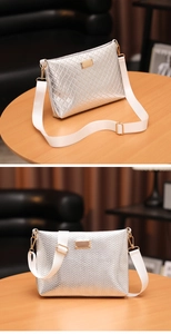 Detail of silver crossbody bag with quilted textures and adjustable white nylon strap