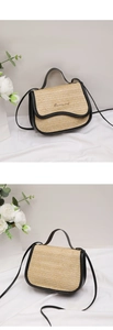 Detail of a beige straw shoulder bag with black leather trim and golden metal logo
