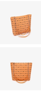 Close-up of orange quilted tote bag with Luck For You print and chain strap detail