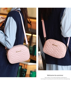 Gros plan du sac bandoulière matelassé rose avec logo doré et bandoulière tissée